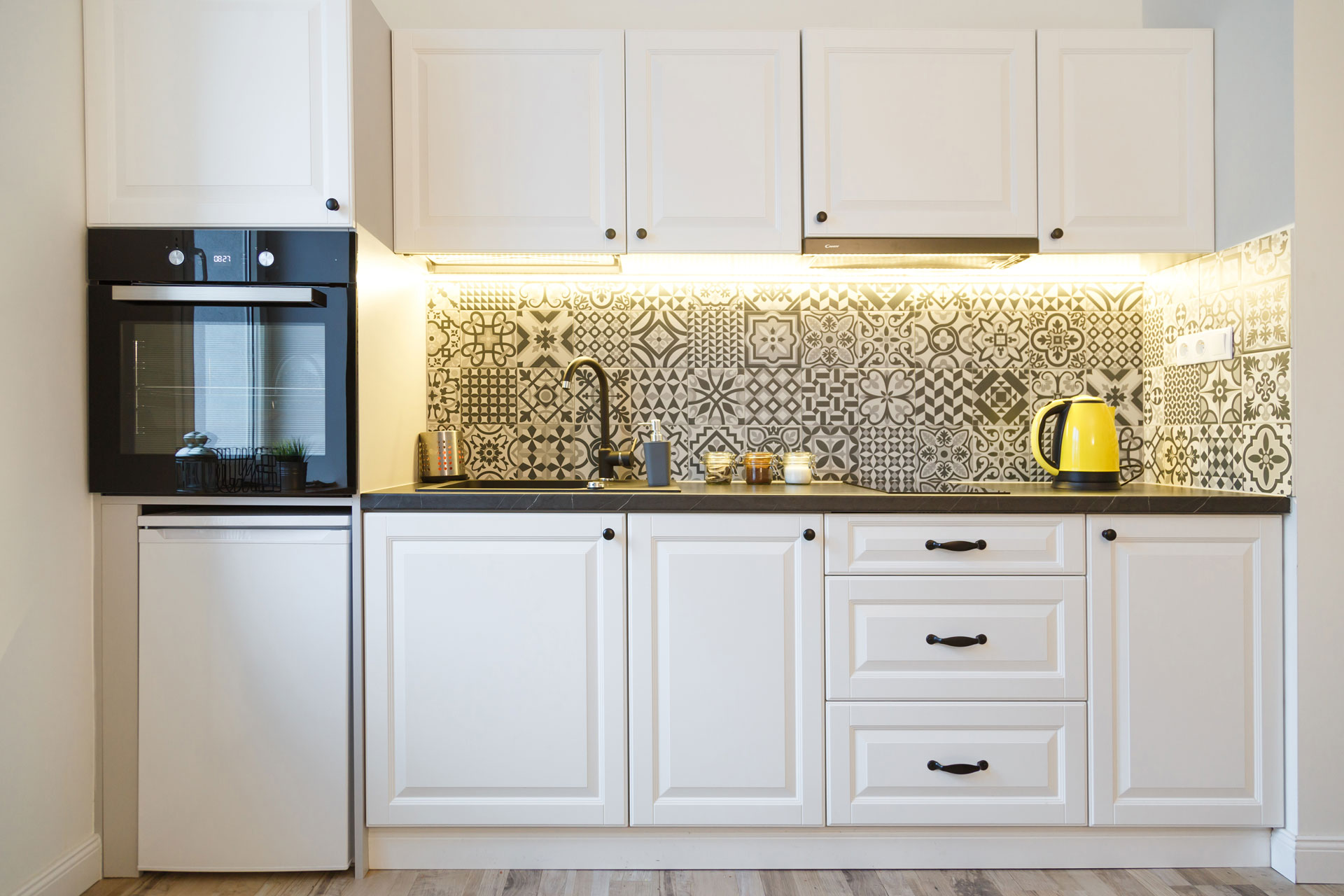 Kitchen with white kitchen cabinets and backlight