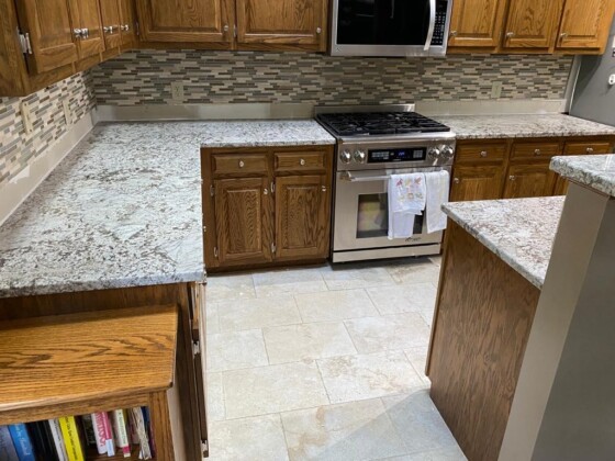 Oak cabinetry kitchen with speckled granite countertops