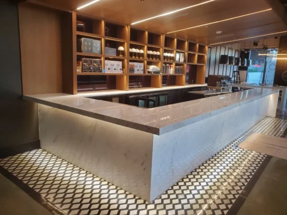 Backlit wooden shelving over polished marble counter