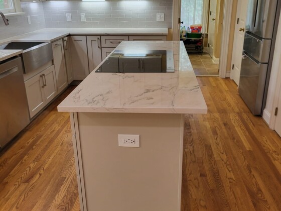 Polished marble island with black induction cooktop