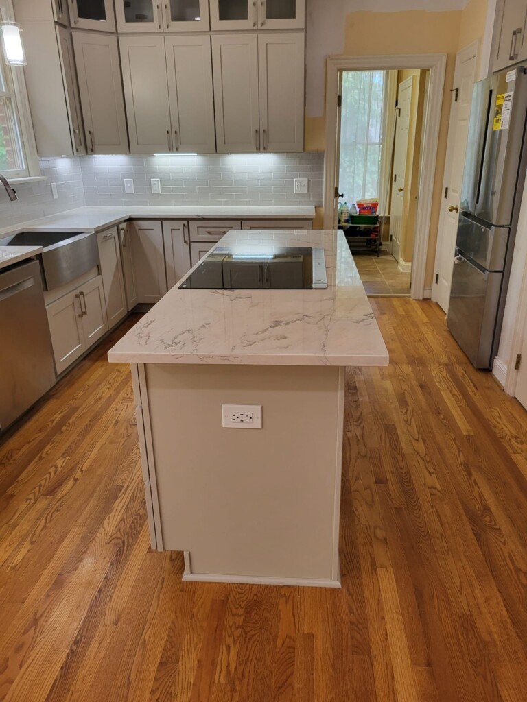 Polished marble island with black induction cooktop