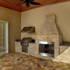Indoor patio with stone fireplace and grill