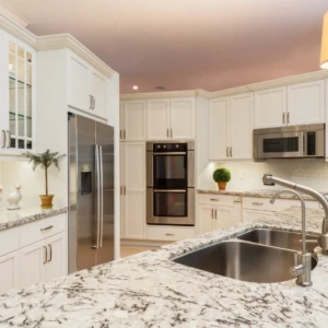 Spacious white kitchen with marble island countertop