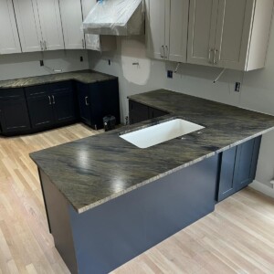 Modern kitchen with dark and light cabinets and a sleek countertop.