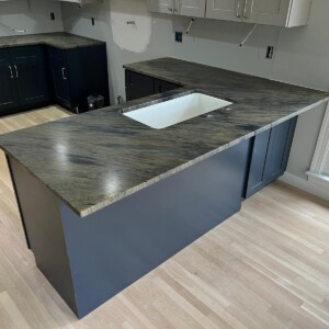 Newly installed kitchen countertops with a sink on a wooden floor.