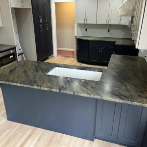 Kitchen with dark granite countertops and blue cabinetry.