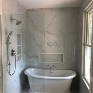 Freestanding bathtub in marble-tiled bathroom
