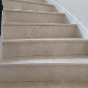 Close-up of beige marble stairs with subtle veining and smooth texture.