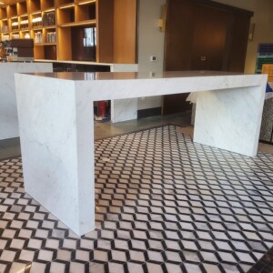 Modern white marble table on a patterned tile floor in a stylish room.
