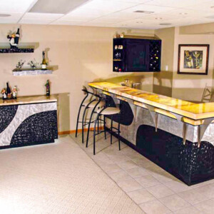 Modern home bar with black and silver design and high stools.