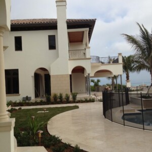 Modern house with a swimming pool enclosed by safety fencing.