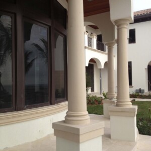 Elegant columns and arches decorate a white building with large windows.