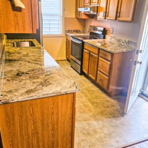 Marbled granite galley kitchen with oak cabinets