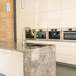 Modern kitchen with sleek cabinetry and granite island.