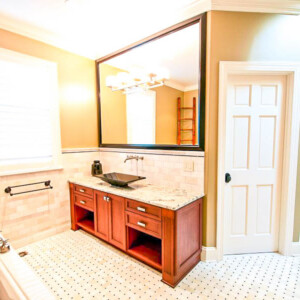 Elegant bathroom with wooden vanity, large mirror, and glass shower.