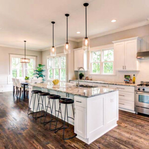 Modern kitchen with white cabinets, marble island, and dark wooden floors.