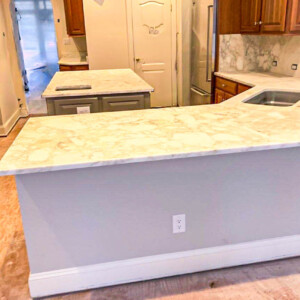 Newly installed marble kitchen countertops with people inspecting the space.