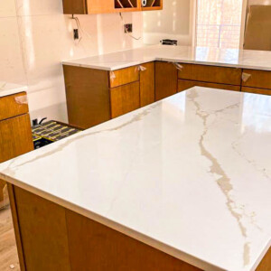 New kitchen with white marble countertops and wooden cabinets.