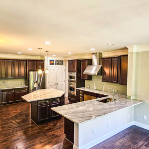 Modern kitchen with dark wood cabinets and marble countertops.