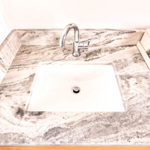 Modern bathroom sink with a sleek chrome faucet and marble countertop.