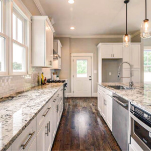Modern kitchen with white cabinets and granite countertops.