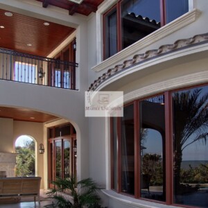 Elegant Mediterranean-style house exterior with arches and large windows.
