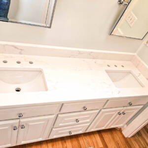 White double sink bathroom vanity with marble countertop and wooden floor.