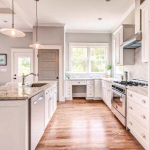 Bright modern kitchen with white cabinets and wooden floors.