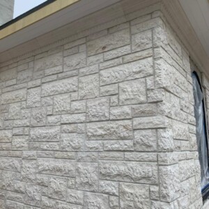 Close-up of a textured stone brick wall corner on a building.
