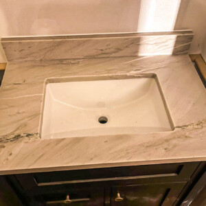Newly installed marble countertop with a rectangular sink in a bathroom vanity.