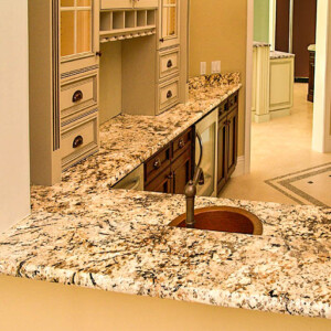 Polished granite countertop with built-in sink in a kitchen pass-through window.